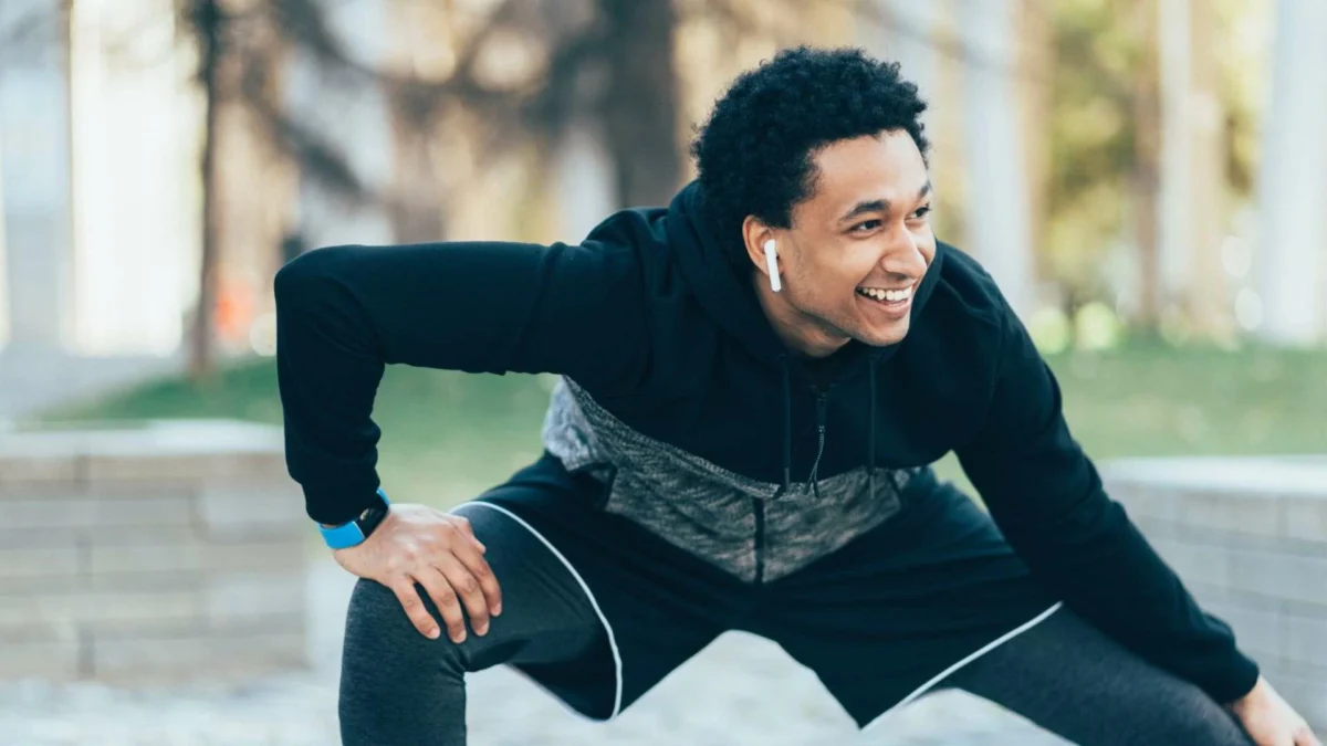 This image showcases a man in a calm state while stretching, his smile symbolizing the confidence and mental performance that precede a successful endeavor.