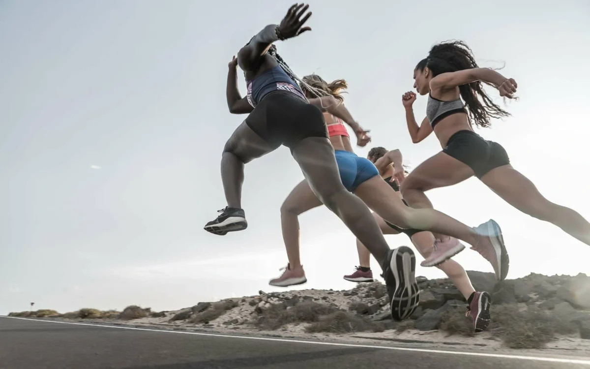 This image shows four women sprinting in a race, their expressions of intense focus and determination highlighting the mental strength needed to compete.