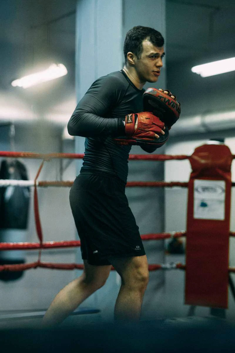 This image shows a boxer practicing inside the gym, doing shadow boxing, which highlights the mental focus and visualization needed for combat sports.
