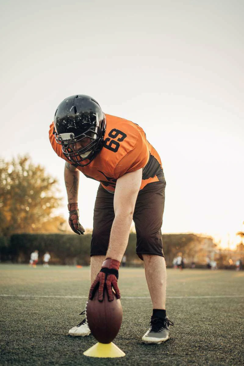 This image shows a rugby player on the field, with the ball in his hands, focused on setting it in its place and preparing for the game, a key moment of mental performance.