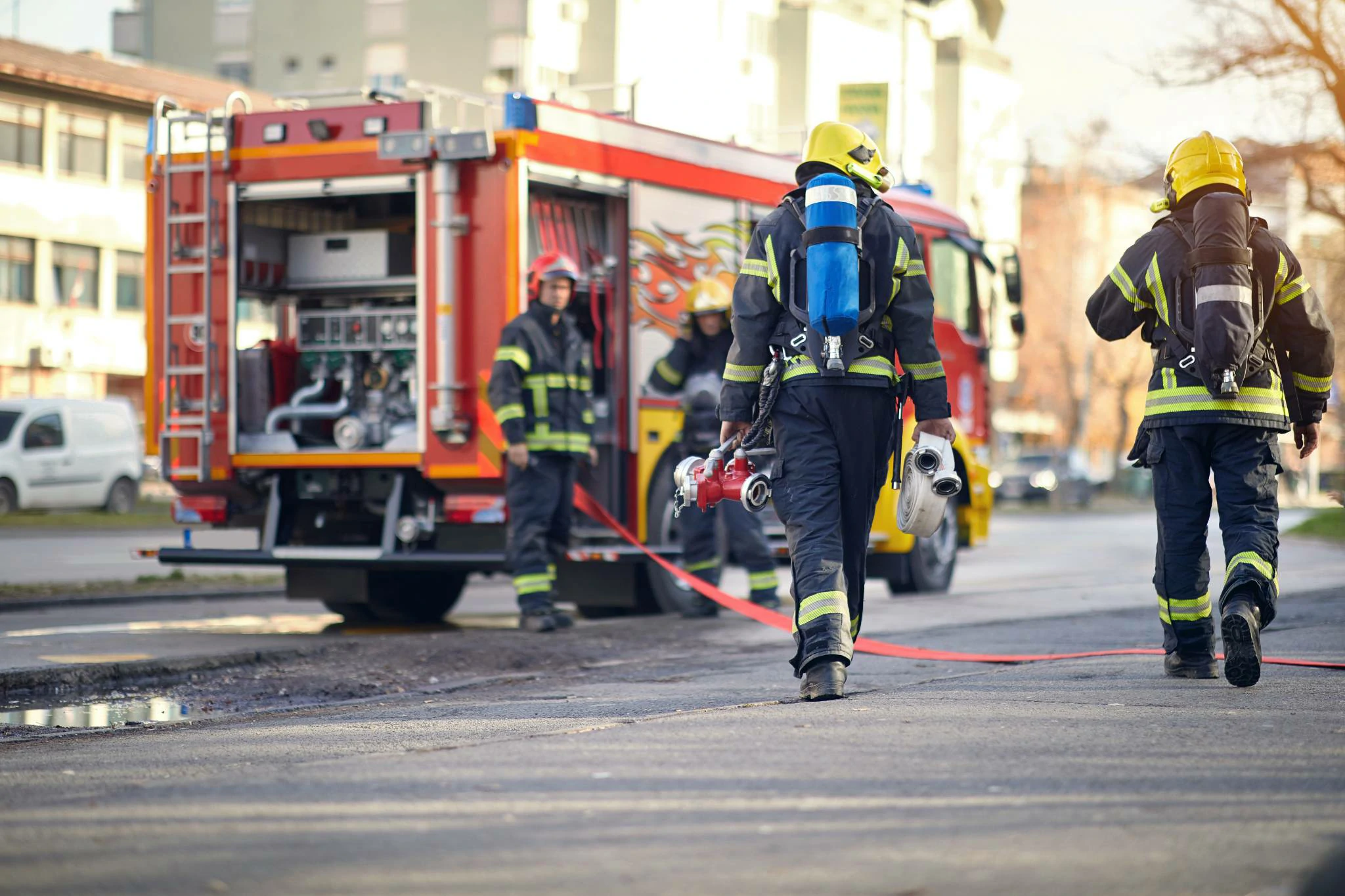This image shows a firefighter in a suit, walking toward their vehicle, illustrating the mental strength and resilience required for their work.