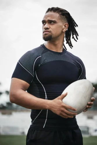 This image shows a male rugby player looking into the distance, focused on his practice.